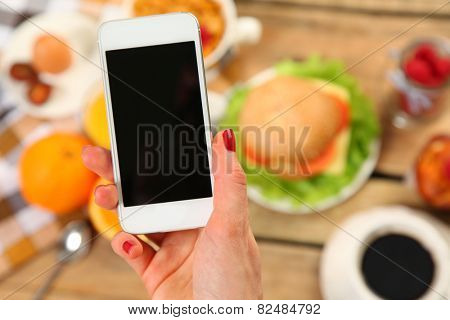 breakfast and mobile phone on wooden table