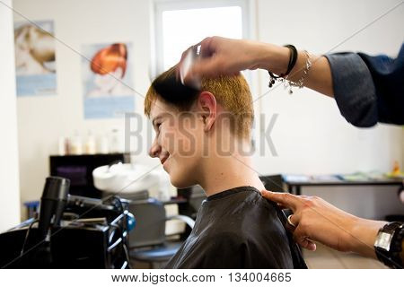 Smiling Young Boy With Red Hair At The Hairdresser