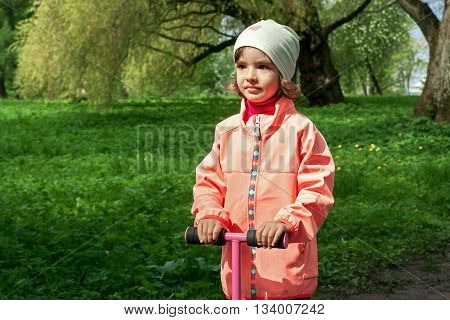 Cute girl is walking in a beautiful green park.