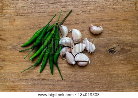 gralic and green chilli on wooden background