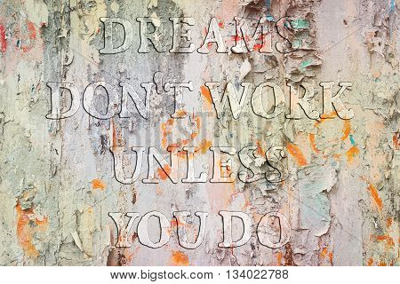 Dreams don't work until you do. Motivational quote about success and self actualization. Uneven transparent protuberant font on a grunge wall background.