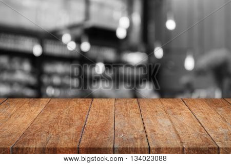 Wooden tabletop with black and white coffee shop blurred background, stock photo