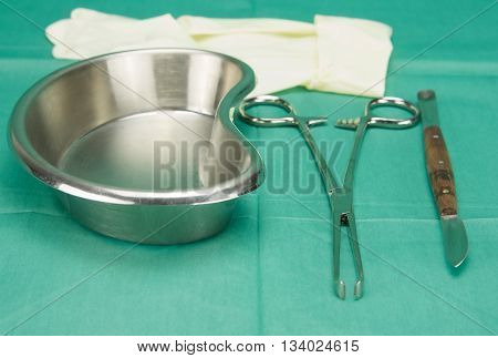 Surgical Clamp And Knife Placed Near Kidney Shape Bowl