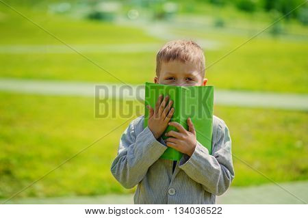 Portrait little boy with book on natue.