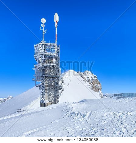 Mt. Titlis, Switzerland - 9 March, 2016: tower with telecommunication equipment on the top of the mountain. Titlis is a mountain located on the border between the Swiss cantons of Obwalden and Bern, mainly accessed from the town of Engelberg.