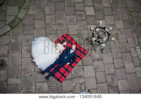 Wedding Couple Lying On Blankets. Photo From Quad Copter Drone View