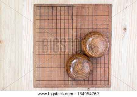 top view two wooden bowls filled black and white stones over empty go game board included clipping path traditional chinese strategy board game sport hobby and recreation