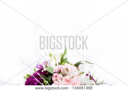 Bouquet from pink and purple gillyflowers and alstroemeria on the bottom of white background