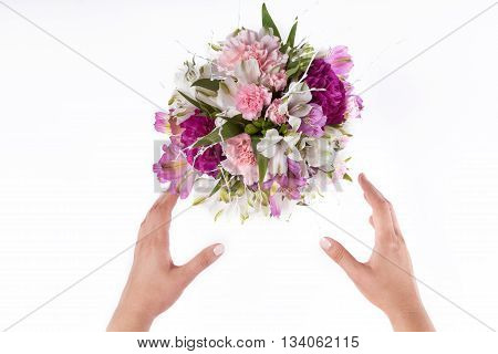 Hands receiving a pastel bouquet from pink and purple gillyflowers and alstroemeria