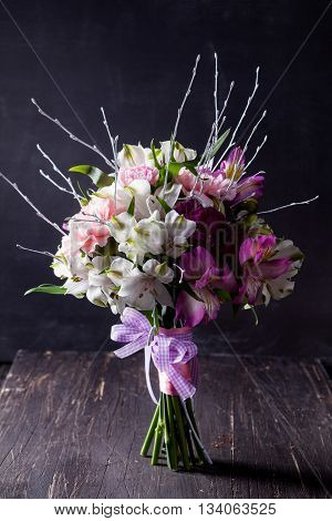 Pink bouquet from gillyflowers and white alstroemeria on blackboard and old wood