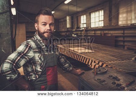 Carpenter doing his job in carpentry workshop.