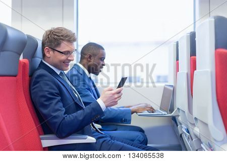 Smiling businessmes in a train