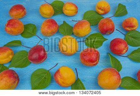 Pile of ripe red apricots on the wooden table; rural vintage concept. Concept of organic farming; fresh natural unprocessed fruit. Tilted perspective.