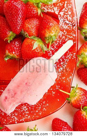 Homemade ice cream popsicles with fresh strawberries. Light organic summer dessert with ripe berries.