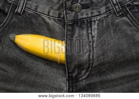 banana fruit in condom inside jeans pants contraceptive concept