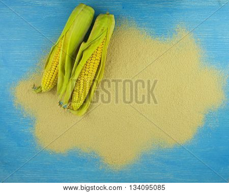 corn flour and corn on the cob on a wooden table