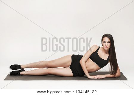 Portrait of young attractive woman doing exercises. Brunette with fit body on yoga mat. Healthy lifestyle and sports concept. Series of exercise poses.