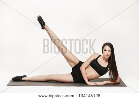 Portrait of young attractive woman doing exercises. Brunette with fit body on yoga mat. Healthy lifestyle and sports concept. Series of exercise poses.