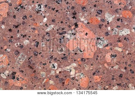 Surface of a porphyry rhyolite rock from central Europe Saxony-Anhalt. The rock contains fragments of feldspars quartz and amphibole minerals in a fine grained matrix.