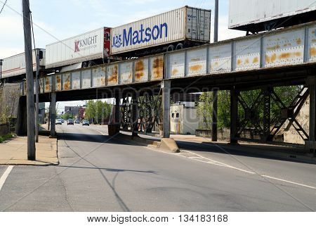 JOLIET, ILLINOIS / UNITED STATES - MAY 3, 2015: A freight train crosses a bridge over Scott Street near downtown Joliet, Illinois.