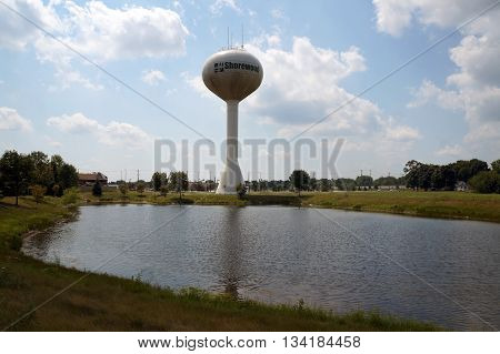 SHOREWOOD, ILLINOIS / UNITED STATES - AUGUST 16, 2015: The Shorewood Water Tower towers over a retention pond in Shorewood.