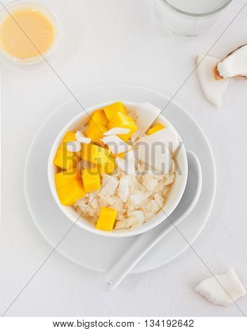 Rice pudding with mango and coconut water in a bowl, khao niaow ma muang White background Copy space Top view