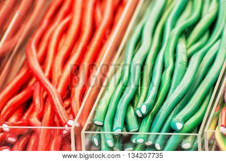 Colorful tasty licorice candies in plastic containers. Sweet delight. Vibrant colors. Sweetmeats scene. Confectionery in the shop.