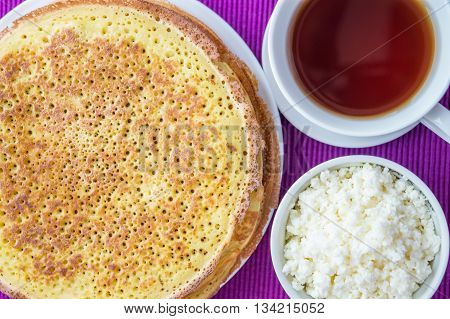 Pancakes with cheese and cup of tea.