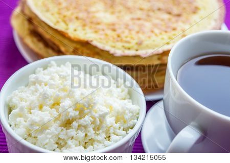 Pancakes with cheese and cup of tea.