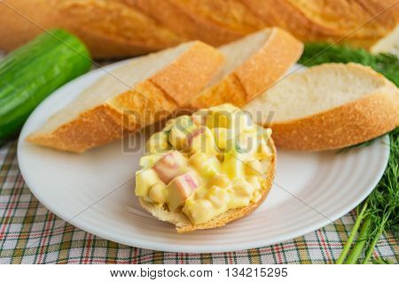 Light salad of cucumber crab meat corn and quail eggs with aioli sauce on crispy baguette