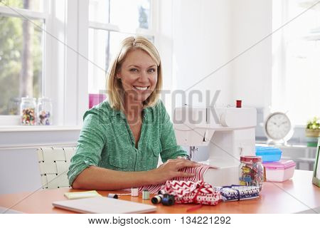 Woman Making Clothes Using Sewing Machine At Home
