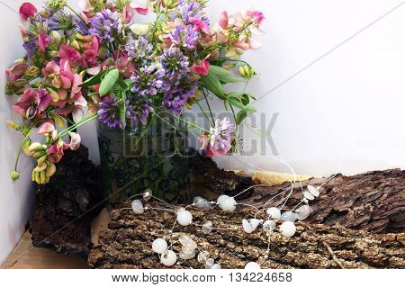Composition with motley bouquet and white beads