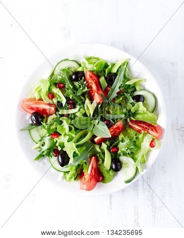 Tomato and cucumber salad with olives and pomegranate seeds
