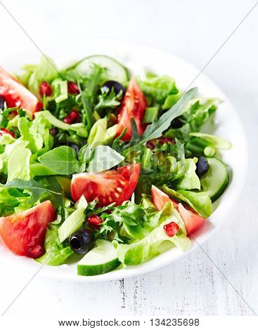 Tomato and cucumber salad with olives and pomegranate seeds