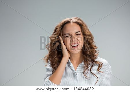 A picture of young woman with earache over gray background