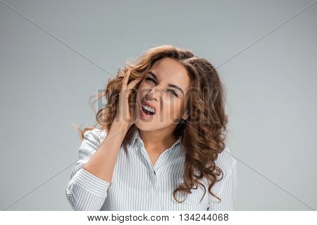 A picture of young woman with earache over gray background