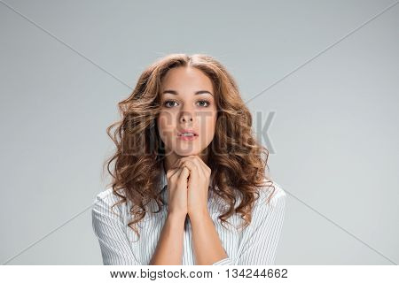 The Woman is looking imploring over gray background
