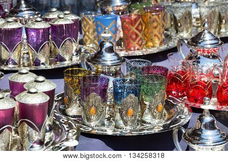 Traditional teapots with tea glasses on a tray sold in the souks of Marrakesh Morocco