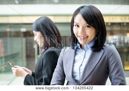 Businesswomen with one working on cellphone 