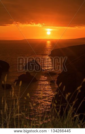 beautiful sunset over the coastal rocks with wild highl grass on the wild atlantic way