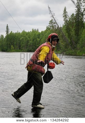 KOLSKYY RUSSIA - AUGUST 14 - Caucasian tourist in life jackets and helmet standing in lake in Kolskyy on August 14 2008