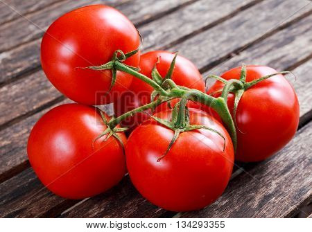 Organic Vine ripe tomatoes on wooden table.