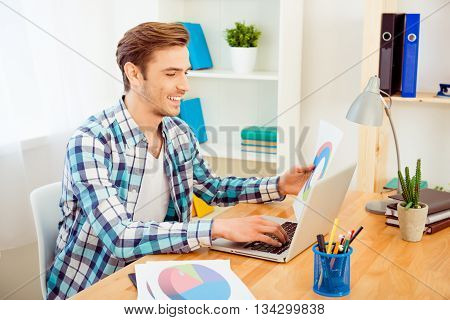 Happy Businessman Holding Paper With Diagrama And Using Laptop