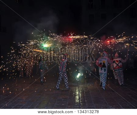 Correfocs (fire runs) or Baile de Diablos (Devils' Dance) - essential part of tradition originating from Catalonia. Group of people dressed as devils and dancing with lighting fireworks. Reus Spain.