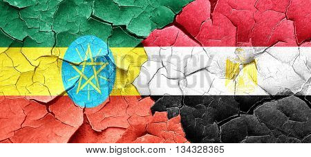 Ethiopia flag with egypt flag on a grunge cracked wall