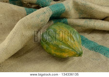 Whole raw uncooked acorn squash on burlap