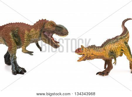 tyrannosaurus and carnotaurus toys on white background