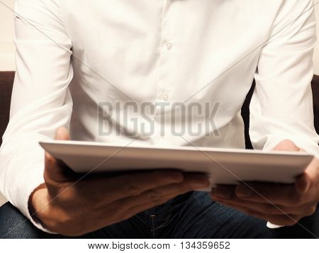 Businessman with a tablet computer reading an ebook selective focus on man