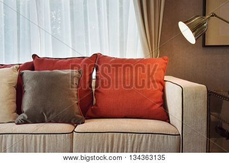 Red And Deep Brown Linin Pillows On Beige Linin Sofa With A Brass Lamp In Modern Classic Living Room