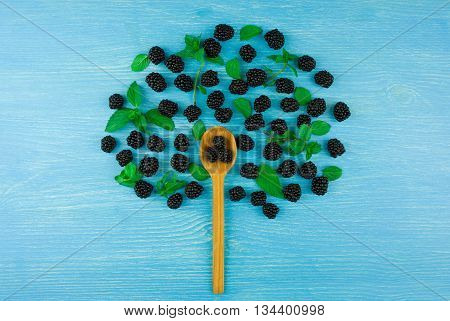 Tree of blackberies on a blue wooden background